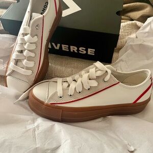 White leather low-top Converse with off-white suede accents and vintage red.